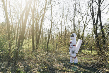 Junger Astronaut auf der Suche im Wald an einem sonnigen Tag - MEUF02811