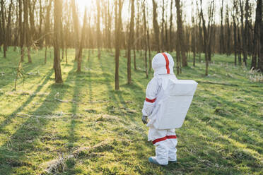 Female explorer in space suit standing at forest - MEUF02839