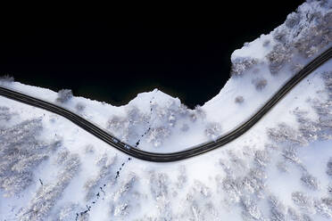 Cars traveling on snowy road on shore of Lake Sils from above, Engadine, Graubunden Canton, Switzerland, Europe - RHPLF19720