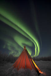 Eine wirbelnde Aurora Borealis (Nordlicht) über einem traditionellen Sami-Tipi in Nordschweden, Skandinavien, Europa - RHPLF19730