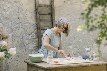 Mature woman preparing dough at back yard - ALBF01597