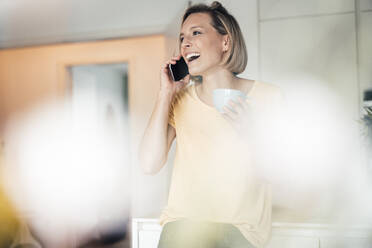 Short haired woman talking on phone at home - JOSEF04533