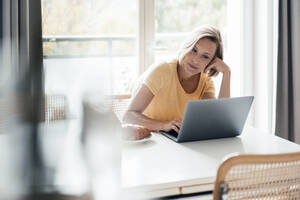 Unternehmerin benutzt Laptop zu Hause - JOSEF04558