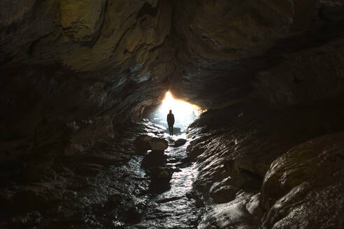 Neuseeland, Südinsel, Fiordland National Park, Mann am Eingang einer Höhle - WVF01865
