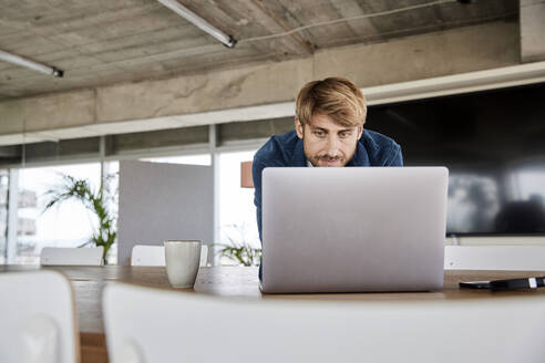 Blonder Mann benutzt Laptop im Loft - FMKF07137