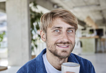 Grauäugiger Mann mit Kaffee im Loft - FMKF07140