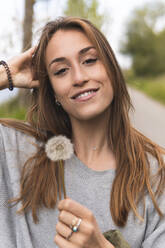 Beautiful woman with hand in hair in nature - JAQF00623