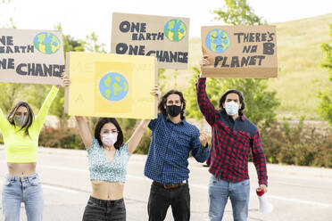 Men with women wearing face mask protesting on footpath - JCCMF02428