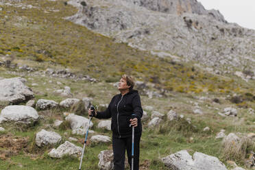 Ältere Frau in Sportkleidung beim Wandern auf einem Berg - ASSF00069