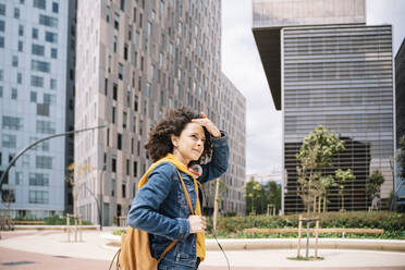 Young beautiful woman looking away in city - JCZF00712