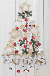Arrangement of homemade cookies and various Christmas decorations hanging on wooden wall - GWF07011