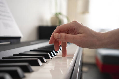 Mittlere erwachsene Frau spielt zu Hause Klavier - VPIF03993