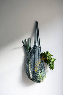 Gemüse im Netzbeutel an der Wand hängend - OJF00453