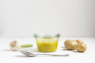 Suppe mit Gemüse und Löffel auf weißem Hintergrund - OJF00459