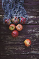 Apples with mesh bag on wooden table - OJF00485