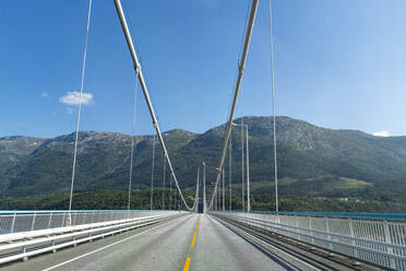 Norwegen, Leere Landstraße der Hardangerbrücke an einem sonnigen Tag - RUNF04380