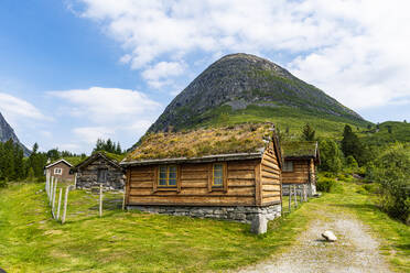 Huts on meadow in front of mountain - RUNF04395