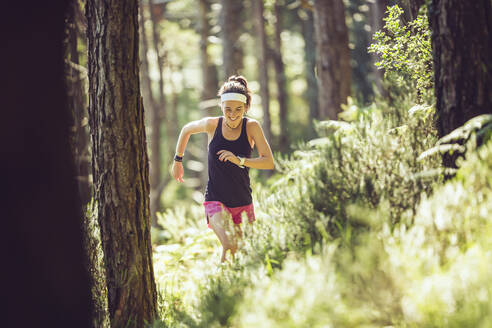 Active female athlete running in forest - MTBF00992