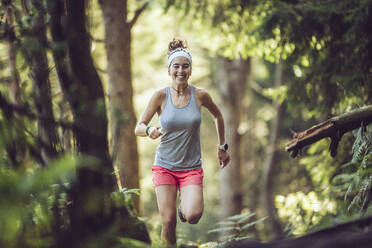 Aufgeregte junge Sportlerin beim Laufen im Wald - MTBF01001