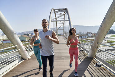 Multiethnische gesundheitsbewusste Freunde laufen auf der Brücke - VEGF04476