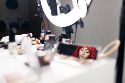 Reflection of female make-up artist in mirror at studio - MRRF01154