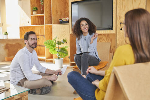 Entrepreneurs discussing while sitting in creative office - AKLF00203