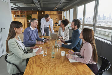 Unternehmer, die am Konferenztisch sitzend ihren Geschäftsplan besprechen - AKLF00220