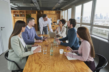 Businesswoman explaining plan to colleagues in board room - AKLF00221