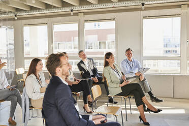 Male and female colleagues attending educational training class at office - AKLF00251