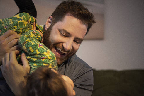 Fröhlicher Vater spielt mit seiner Tochter zu Hause - MJRF00404