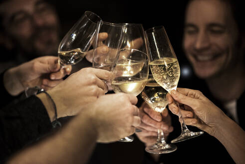 Happy male and female friends toasting glasses during celebration at home - MJRF00432