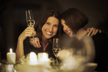 Glückliche Freundinnen trinken Wein zu Hause - MJRF00474