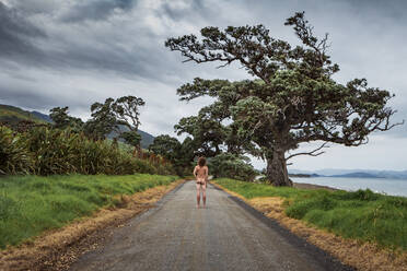 Neuseeland, Nordinsel, Coromandel, Rückansicht eines Mannes auf der Straße mit Blick auf die Jackson Bay - WVF02015