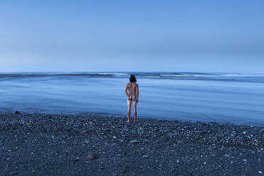 Neuseeland, Südinsel, Karamea, Rückansicht eines nackten Mannes mit Blick auf das blaue Meer - WVF02025