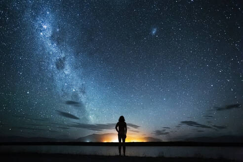 Neuseeland, Canterbury, Twizel, Silhouette eines Mannes mit Blick auf den Poaka-See unter Sternenhimmel - WVF02032