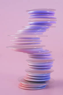 Three dimensional render of stack of purple rings floating against pink background - JPSF00220