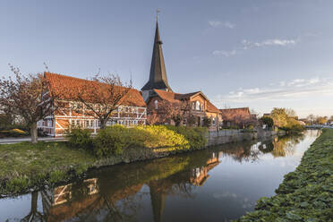 Deutschland, Altes Land, Jork, Fachwerkhäuser und St. Nikolai Kirche spiegeln sich im Kanal - KEBF01939