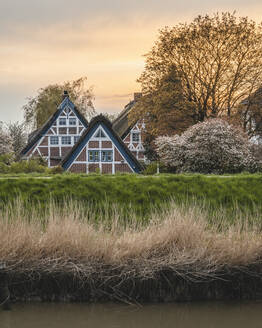 Deutschland, Altes Land, Jork, Idyllische ländliche Szene mit Fachwerkhäusern im Frühling bei Sonnenuntergang - KEBF01950