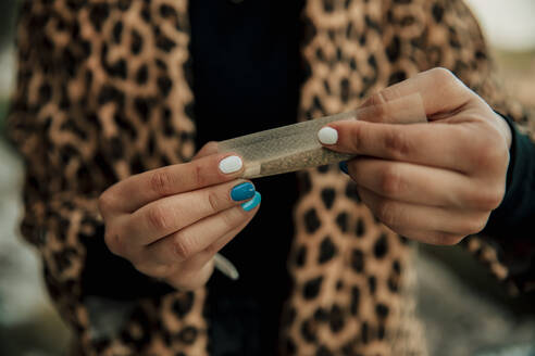 Frau dreht Marihuana-Zigarette im Freien - ACPF01233