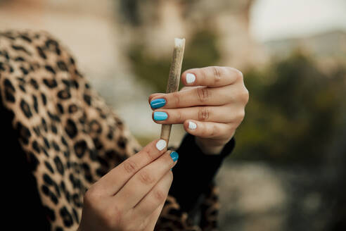 Junge Frau macht Marihuana-Zigarette im Freien - ACPF01234