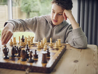 Intelligenter Junge spielt zu Hause Schach - PWF00362