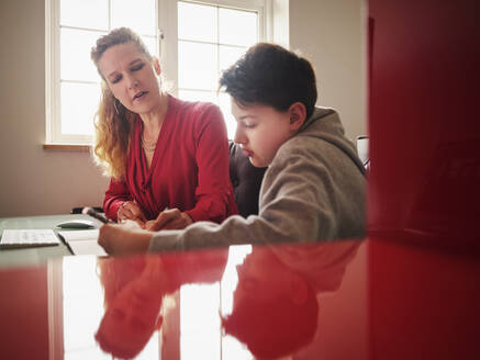 Seriöser Sohn mit Mutter beim Lernen zu Hause - PWF00377