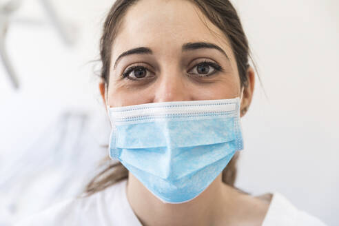 Female dentist wearing surgical mask at clinic - WPEF04491