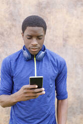 Young man with wireless headphones using mobile phone - IFRF00623