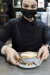Kellnerin serviert Kaffee bei der Arbeit im Cafe - IFRF00660