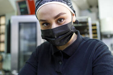 Inhaberin mit Gesichtsschutzmaske in einer Bäckerei - IFRF00695