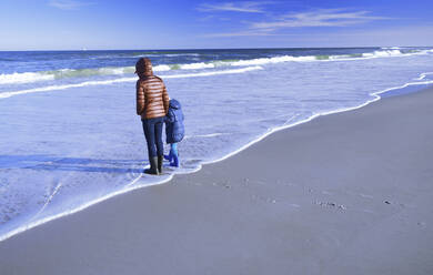 Mutter mit Tochter am Ufer des Strandes - AZF00327