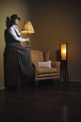 Frau hält Lampe in Dunkelkammer - AZF00331
