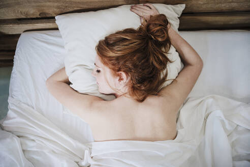 Junge Frau mit Rothaarigen, die zu Hause auf dem Bett schlafen - EBBF03543