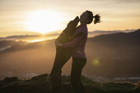 Young woman embracing dog outdoors - SNF01433